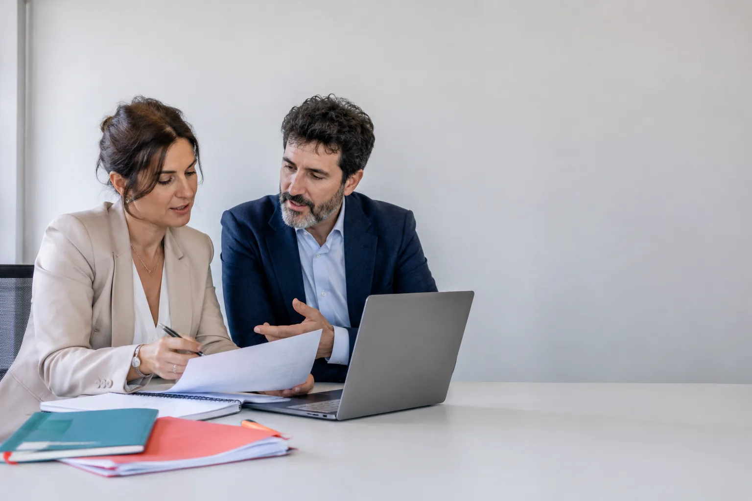 Escena editorial de dos profesionales revisando un an&aacute;lisis en equipo